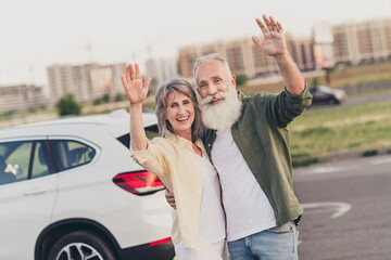 Sticker - Photo of senior cheerful couple embrace wave hands hello transport road street vehicle trip outdoors