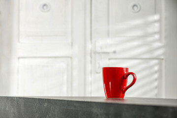 Wall Mural - Red mug on desk and white wooden doors. 