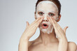 © VICHIZH - emotional woman cosmetic face mask close-up light background