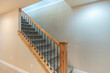 Carpeted stairs with wooden handrailing and wrought iron baluster
