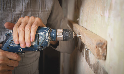 Wall Mural - Man holds a drill. Doing home renovation