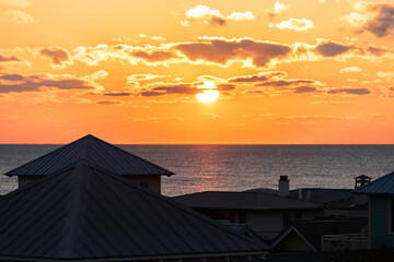 Wall Mural - High angle aerial view on colorful yellow sunset ocean landscape horizon of Gulf of Mexico in Seaside, Florida and buildings houses cityscape