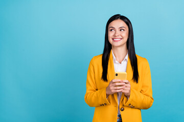 Wall Mural - Photo of inspired happy attractive business woman hold telephone think sms look empty space isolated on blue color background