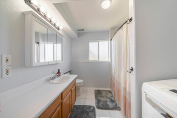 Interior of a bathroom with window and laundry units