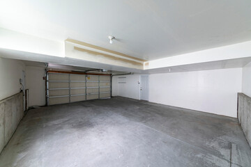 Garage interior with automatic sectional door and white fire door