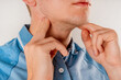© KseniaJoyg - A man checks the lymph nodes on his neck.