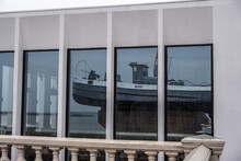 An Old Tugboat With A Cannon In The Reflection Of A Glass Showcase Of A Building On The Embankment Of Nizhny Novgorod 