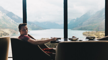 Wall Mural - silhouetted man looking at camera with beautiful mountains in background