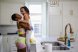 © Creative Flame - Mother lifting daughter in kitchen