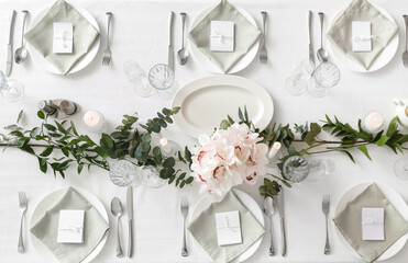 Beautiful table setting for wedding celebration with burning candles in restaurant