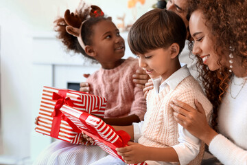 Canvas Print - Parents giving presents to their children at home on Christmas eve