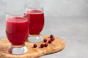 Wall Mural - Two glasses with homemade freshly cranberry juice on a gray concrete table