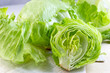 Fresh green iceberg lettuce salad leaves cut on light background on the table in the kitchen.