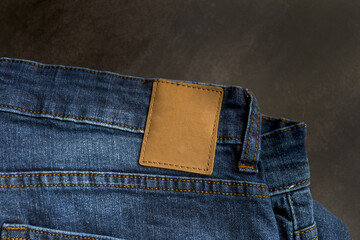 Wall Mural - Top view of an empty blank brown leather label on blue denim jeans