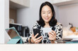 © bignai - Portrait of woman buying online with credit card using smart phone sitting at home.