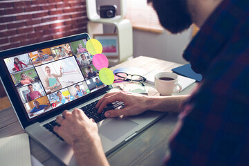 Poster - Caucasian man using laptop for video call, with smiling diverse elementary school pupils on screen