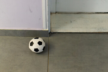 Wall Mural - Close up of a soccer ball on the gray tiled floor at home in Poznan, Poland