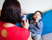 Caucasian Woman Taking A Photo Of A Two Years Old Boy With A Nokia Lumia Windows Smartphone At Home