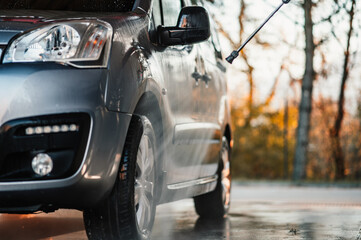 Canvas Print - Manual car wash with white soap, foam on the body. Washing Car Using High Pressure Water.