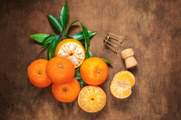 Wall Mural - Christmas background with Fresh juicy Mandarines oranges fruits with wine cork on a wooden table. Copyspace..