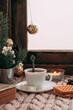 a cup of coffee with white berries, spruce branches, a garland and marshmallows
