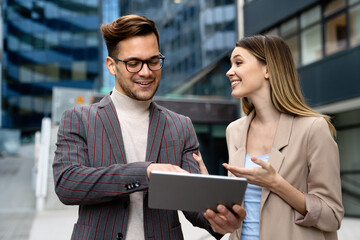 Portrait of successful business people working, talking together in urban background.