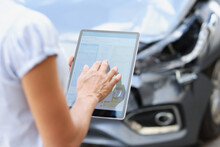Agent Driver Filling Out Insurance Claim On Digital Tablet Against Background Of Broken Car Closeup
