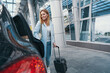 © Viacheslav Yakobchuk - Female passenger with baggage standing before automobile