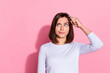 Photo of unsure thoughtful young woman wear white sweater finger head forget important thing isolated pink color background