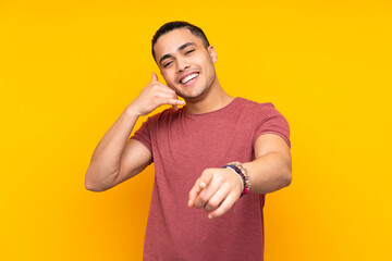 Wall Mural - Asian handsome man isolated on yellow background making the gesture of being late