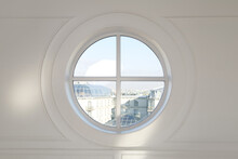 Round Window Overlooking The City In The White Wall.