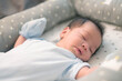 © Thannaree - Asian baby sleeping on gray bed