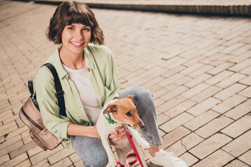 Canvas Print - Photo of pretty charming young lady dressed green shirt backpack walking holding small friend smiling outdoors urban park