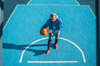 © Yakobchuk Olena - Multiracial basketball player wearing headphones training alone at the stadium