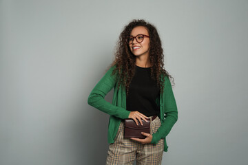 Canvas Print - Beautiful African American woman with stylish waist bag on grey background