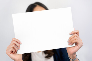 Close up of hand business woman showing blank paper in front of her head.