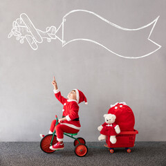 Canvas Print - Happy child riding bike. Christmas holiday concept