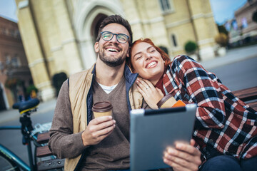 Wall Mural - Trendy young couple in town using tablet and credit card.