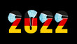 2022 with flag of Germany and medical mask for protection against covid on black background