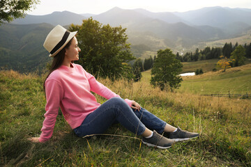 Wall Mural - Young woman enjoying beautiful view of mountain landscape