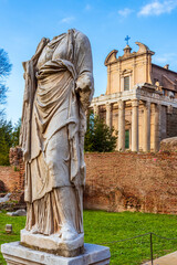 Wall Mural - Headless ancient roman statue in marble standing in front of medieval church facade in Rome