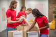 © zinkevych - Young volunteers in red tshirts distributing donations in a sorting center