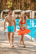 © zinkevych - Two pool lifeguards walking near the public pool and talking