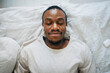 © Maskot - Smiling man wearing wireless in-ear headphones while relaxing with eyes closed