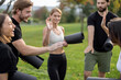 © rh2010 - European people with fitness mats standing and talking in green meadow. Friends practicing yoga and doing sport exercises. Concept of healthy lifestyle. Athletic men and women wearing sportswear