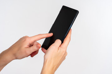 Poster - Hands with phone close-up. Female hands with smartphone. She swipes across display. Smartphone with screen off on light background. Concept of using applications in phone. Place to advertise apps