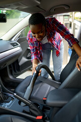 Wall Mural - Woman using vacuum cleaner, hand car wash station