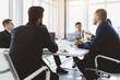 © xartproduction - Group of young business people working and communicating while sitting at the office desk together with colleagues sitting. business meeting
