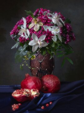Still life with pomegranates and bouquet of flowers