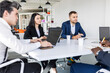 © xartproduction - Group of young business people working and communicating while sitting at the office desk together with colleagues sitting. business meeting